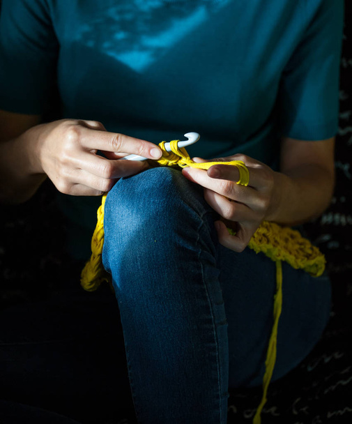 Девочка вяжет вязание дома. Женщина, занимающаяся рукоделием. Трикотаж сидит на диване и работает. Творческое хобби. Навыки терпения и терпения. Толстая пряжа
. - Фото, изображение