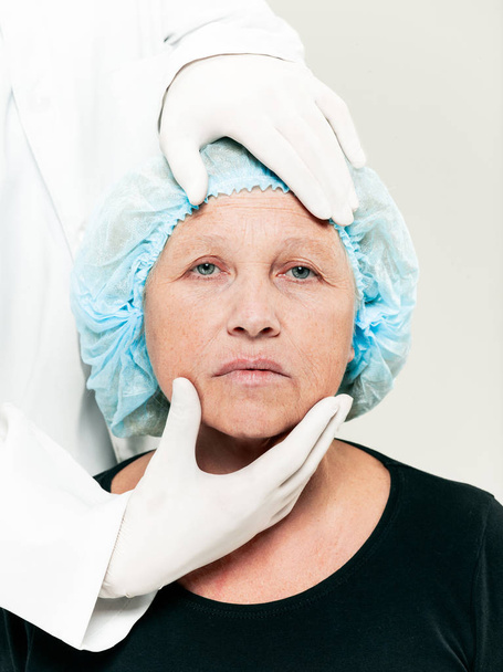 surgeon doing skin check on mid age woman before plastic surgery - Zdjęcie, obraz