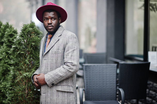 Stylish African American man model in gray coat, jacket tie and red hat.  - Foto, Bild
