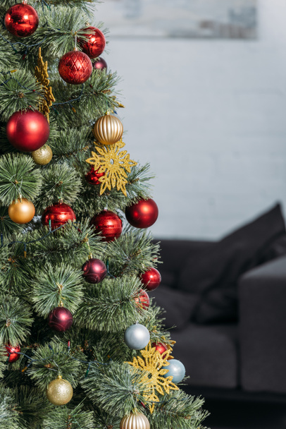  christmas tree with red and golden baubles in living room - Foto, afbeelding