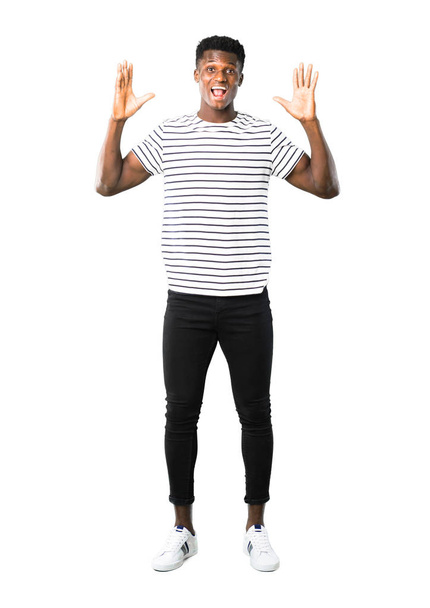 Full body of Dark skinned man with striped shirt with surprise and shocked facial expression. Mouth open because not expect what has happened on white background - Foto, afbeelding
