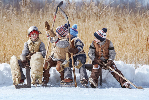 Group of boys are changed for hockey on a bench at a local lake - Fotoğraf, Görsel