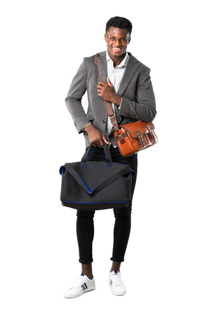 Cuerpo completo de hombre de negocios afroamericano viajando con maletas sonriendo mucho mientras pone las manos en el pecho sobre fondo blanco
 - Foto, Imagen