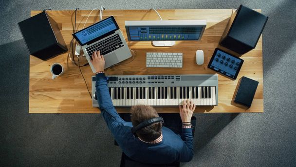 Top View of a Musician Creating Music at His Studio, Playing on a Musical Keyboard. His Studio is Sunny and Pleasant Looking. - Foto, afbeelding