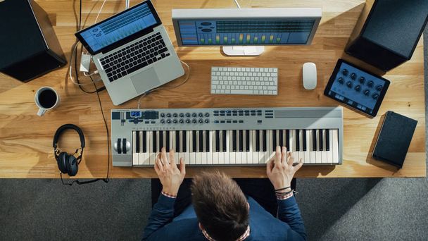 Top View of a Musician Creating Music at His Studio, Playing on a Musical Keyboard. His Studio is Sunny and Pleasant Looking. - Photo, Image
