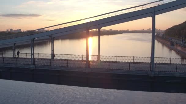 Puente peatonal de tiro aéreo de Kiev al amanecer. Mañana de verano en Kiev, río Dniepeer. Ucrania. Ciudad europea
 - Metraje, vídeo