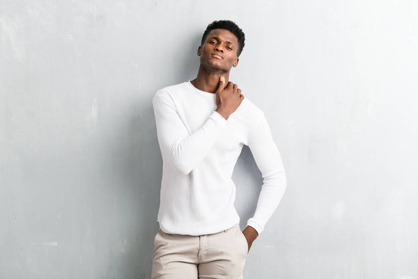 Young afro american man posing on textured grey wall - Φωτογραφία, εικόνα