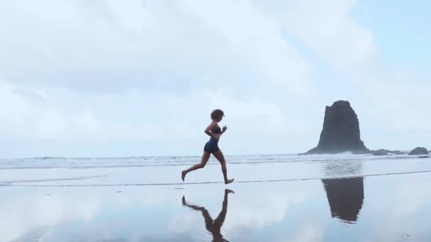 Bosý sportovní dívka s štíhlé tělo běží podél moře surf vody bazénu udržovat fit a zdraví. Pláže na pozadí s modrou oblohou. Žena fitness, běhání sportovní aktivity na letní rodinnou dovolenou. - Záběry, video