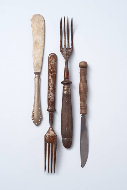Composition from metalic old knives and forks with wooden handles presented on a gray background with space for text. Vintage Collection. Flat lay - Foto, imagen