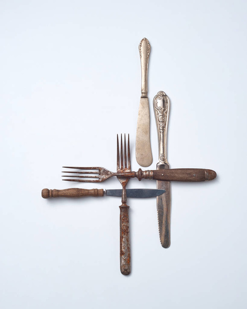 Collection of old metal with wooden handle forks and knives on a gray background with copy space. Vintage Collection. Flat lay - Foto, Imagen