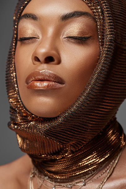πορτρέτο του ελκυστικό αφρικανικό αμερικανικό μοντέλο με Περιτύλιγμα κεφάλι και τα μάτια κλειστά απομονώνονται σε γκρι - Φωτογραφία, εικόνα