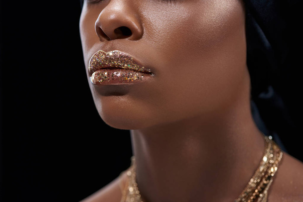 cropped shot of african american woman with sparkling lip gloss isolated on black - Fotoğraf, Görsel