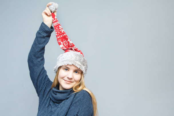 Christmas girl in Santa hat wondered on grey background - Photo, Image