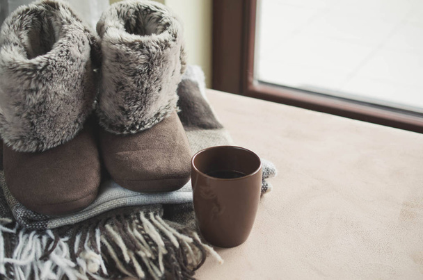 Warm home clothes. Woolen plaid and home slippers and cup of hot beverage. - Photo, Image