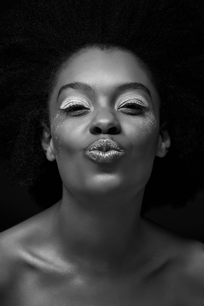 black and white photo of attractive african american woman with duck face isolated on black - Photo, image