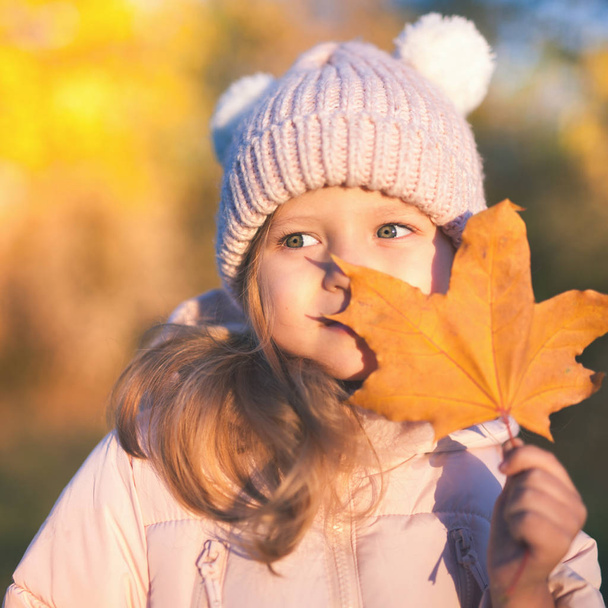 Autumn outdoor portrait of girl holds leaf - Фото, зображення