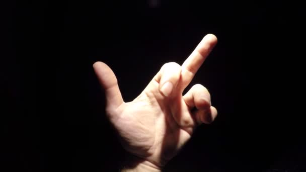 Detailní záběry mužské ruky ukazující gesto prostředníčku na černém pozadí - Záběry, video