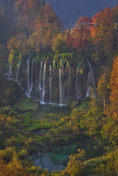 Popular tourist location in the national park. Idea for family vacation. Beautiful autumn colourful forest with waterfall. - Photo, Image