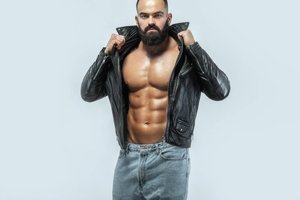 Close-up portrait of a brutal bearded man topless in a leather jacket - Foto, Imagen