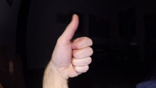 Close-up beelden van mannenhand duim omhoog gebaar toont op zwarte achtergrond - Video