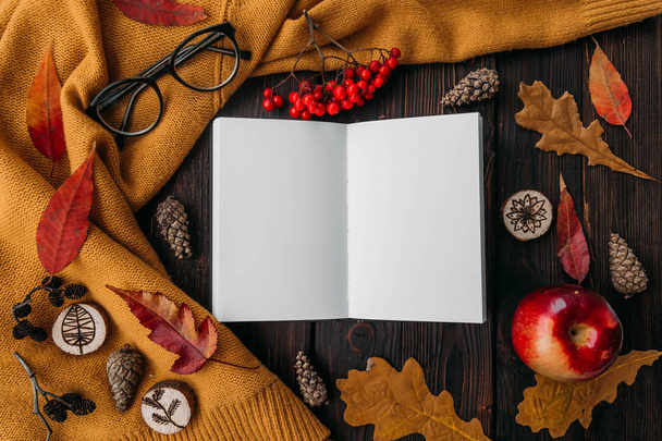 Stylish Flat lay view of autumn leaves and  textured scarf on wooden background with cup  .  Autumn or Winter concept. Place for text - Φωτογραφία, εικόνα