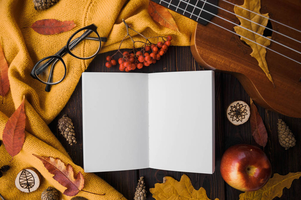 Stylish Flat lay view of autumn leaves and  textured scarf on wooden background with cup  .  Autumn or Winter concept. Place for text - Zdjęcie, obraz