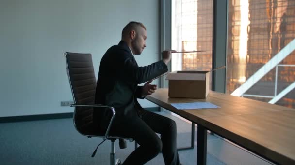 Empresario con caja móvil en artículos de desembalaje de oficina
 - Metraje, vídeo