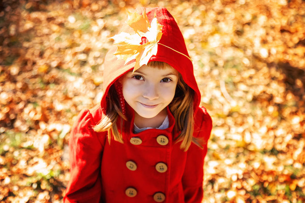 bambino in cappotto rosso con foglie autunnali. Adoro l'autunno. Concentrazione selettiva. natura
. - Foto, immagini