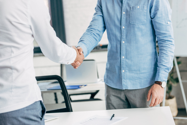 cropped shot of businessmen shaking hands at workplace  - Foto, Imagem