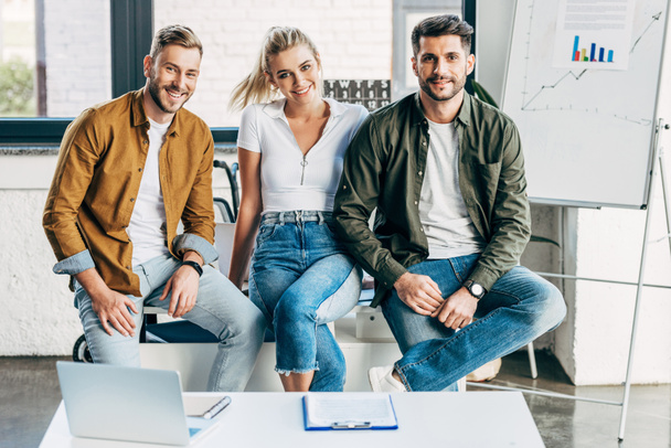 group of smiling young business people looking at camera together at office - Fotoğraf, Görsel