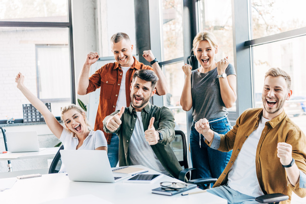 groupe d'entrepreneurs heureux de succès célébrant la victoire et montrant pouces au bureau et en regardant la caméra
 - Photo, image