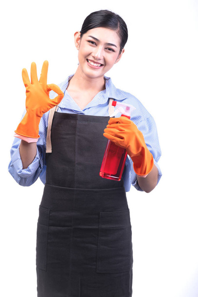 Servicio de limpieza de la casa mujer aislada en blanco. Mujer joven asiática con guantes, sonrisa feliz, pose bien signo. Casa concepto de servicio de limpieza
. - Foto, imagen