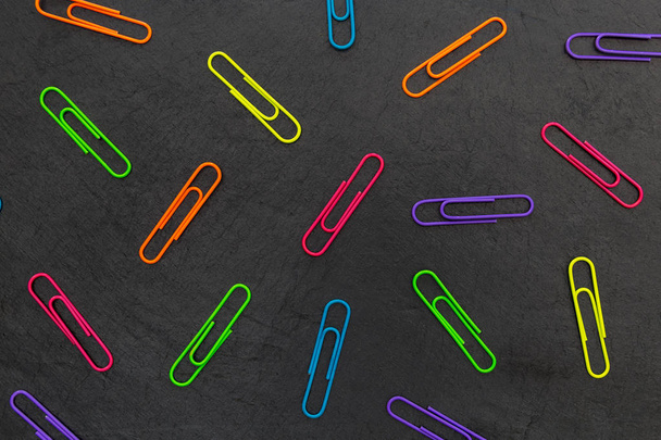 Colorful paperclips stationery on dark background - Photo, Image