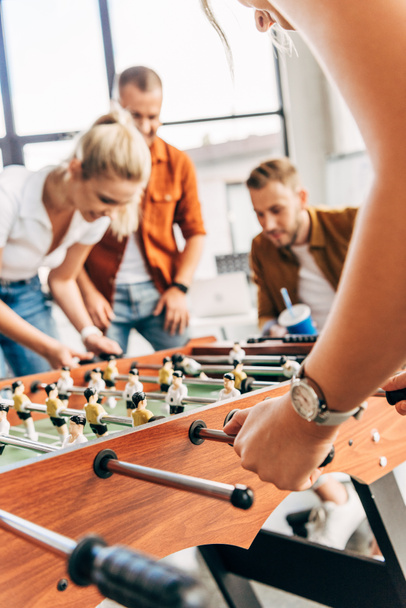cropped shot of young casual business people playing table football at office and having fun together - Fotó, kép