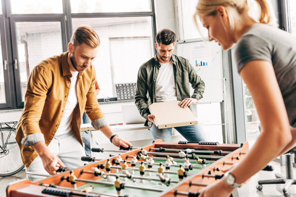 group of happy casual business people playing table football at office and having fun together - 写真・画像
