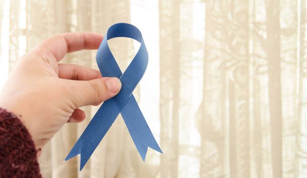 Kobieta ręka trzyma niebieskiej wstążki, niebieski listopada raka prostaty świadomości miesiąca conceot - Zdjęcie, obraz