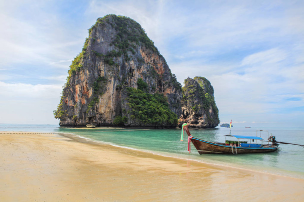Člun dlouhý ocas na tropické pláži s rockem na pozadí - Fotografie, Obrázek
