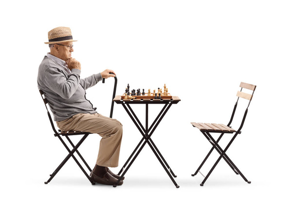 Senior playing chess and thinking about his next move isolated on white background - Фото, изображение