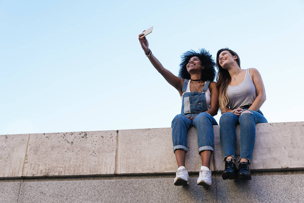 Beautiful women taking a self portrait in the Street. Youth concept. - Photo, image