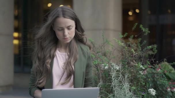 Serious businesswoman working with laptop outside - Felvétel, videó