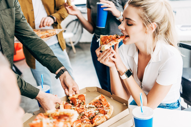 cropped shot of woman having pizza for lunch together with colleagues while working on startup at office - Foto, immagini
