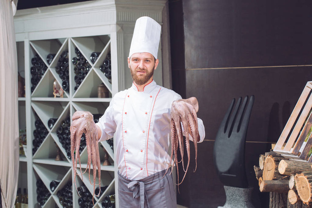 The chef is holding an octopus. - Fotó, kép
