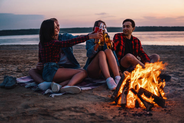 jóvenes amigos tienen picnic con hoguera en la playa
 - Foto, imagen