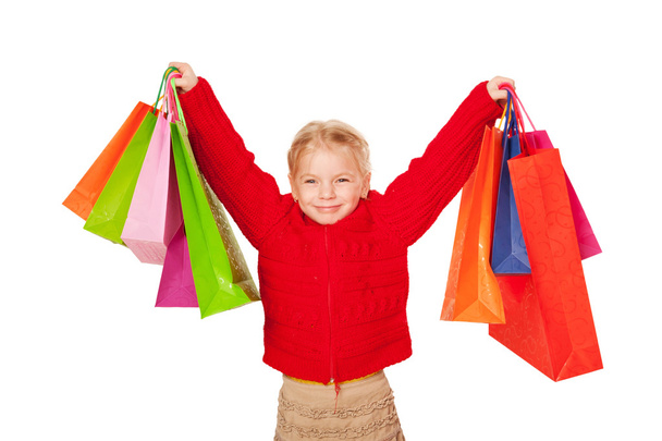 Shopping child. Happy little girl holding up shopping bags. - Foto, Imagen