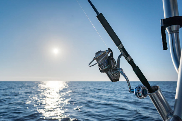 Рибальський стрижень у морському моторному човні під час дня риболовлі в блакитному океані. Успішна концепція риболовлі
 - Фото, зображення