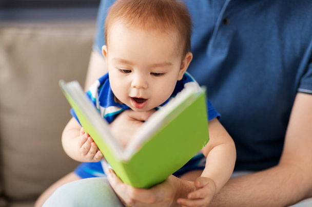 close up of baby boy and father with book at home - Φωτογραφία, εικόνα