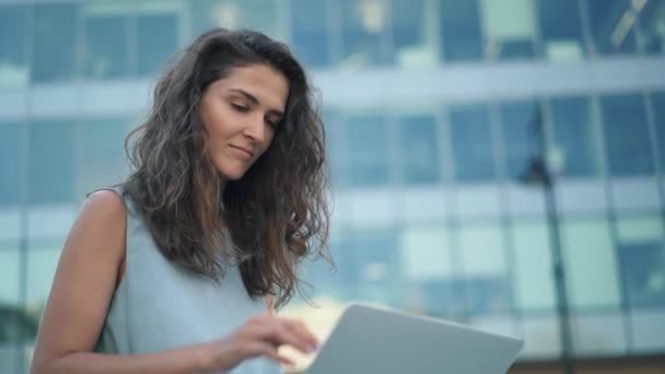 Приваблива молода жінка в блакитній сукні використовує свій ноутбук у центрі міста
 - Кадри, відео