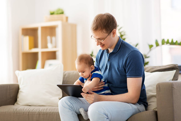 счастливый отец и маленький сын с планшетным компьютером дома
 - Фото, изображение