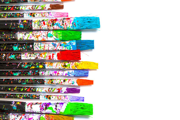 Formación artística. Pinceles para pintores con coloridas manchas de pintura aisladas sobre fondo blanco con espacio para copiar
 - Foto, imagen