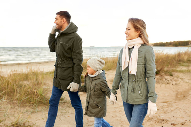 happy family walking along autumn beach - Zdjęcie, obraz